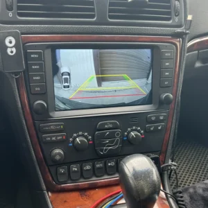 Rear-view camera display with parking guide lines (green, yellow, red) to help reverse into a space behind the car.