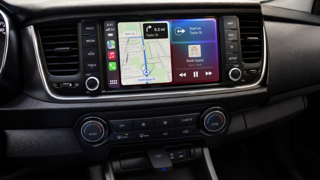 Car dashboard touchscreen with navigation map and music controls on the center console, surrounded by climate and media buttons.